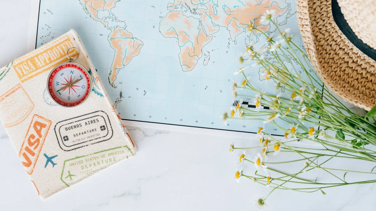 A map, a straw hat, and a passport with a visa stamp.