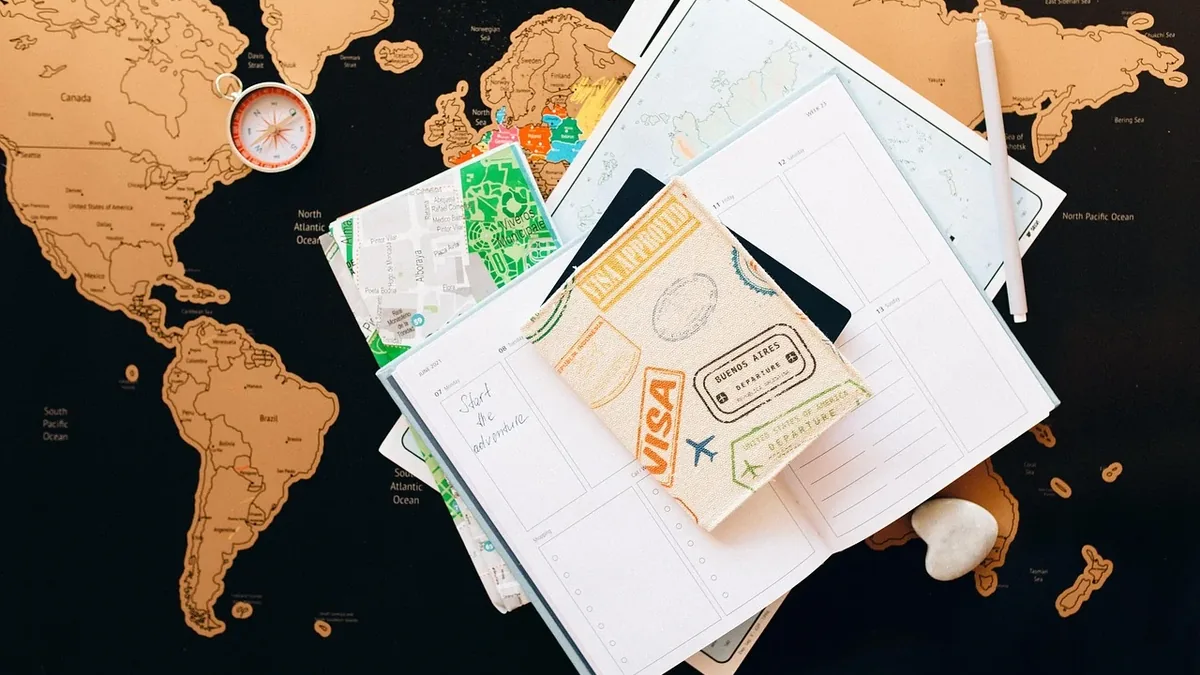 A collection of travel documents, including a passport, visa, and maps, placed on top of a world map.