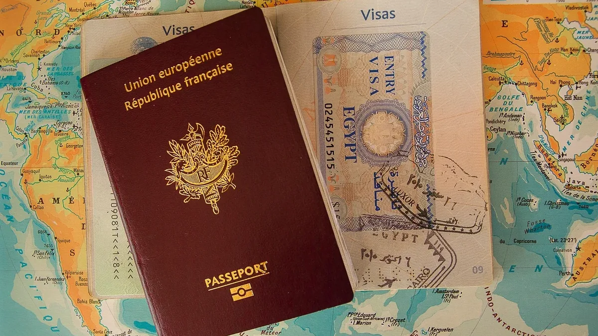 A French passport, a visa, and a map of the world.
